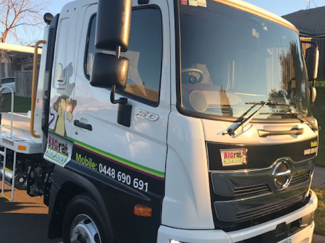 Skip bin truck parked on the side of the road